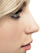 Close-up side profile of VS1 diamond nose ring in piercing, showing flat martini-prong setting on nostril
