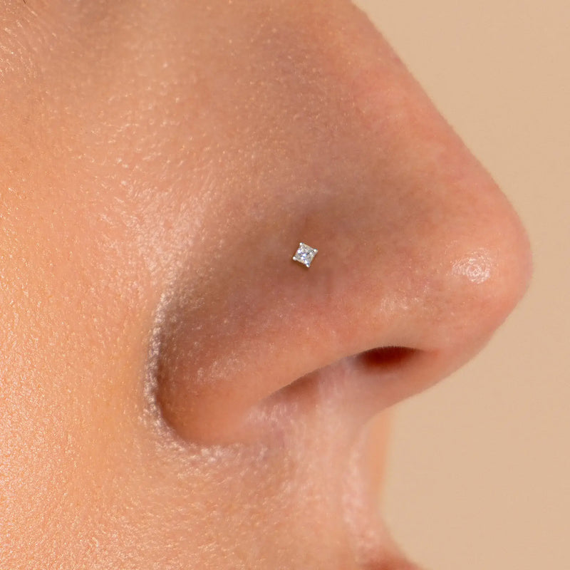 1.5mm princess-cut diamond nose stud shown in pierced nostril, close-up fit view