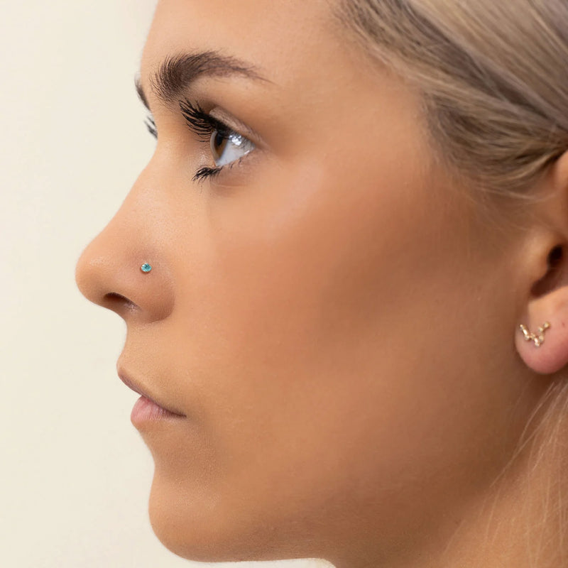 2.5mm aqua diamond nose ring shown in pierced nostril on model, side profile for fit reference