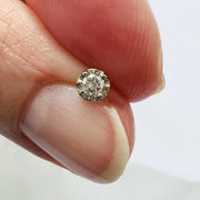 2.5mm illusion diamond labret end held between fingers to show actual tiny size for scale