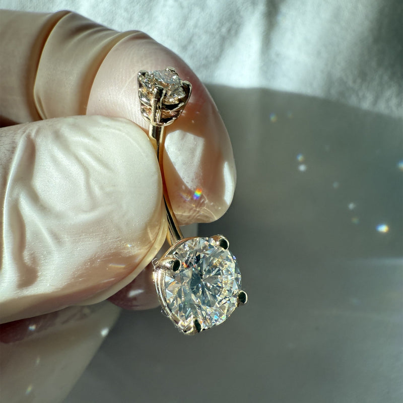14k yellow gold diamond navel ring held at angle showing diamond brilliance and light dispersion