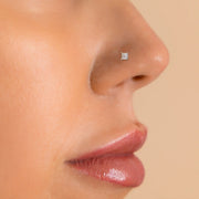 2.5mm princess-cut diamond nose ring shown in pierced nose on model for fit and scale reference