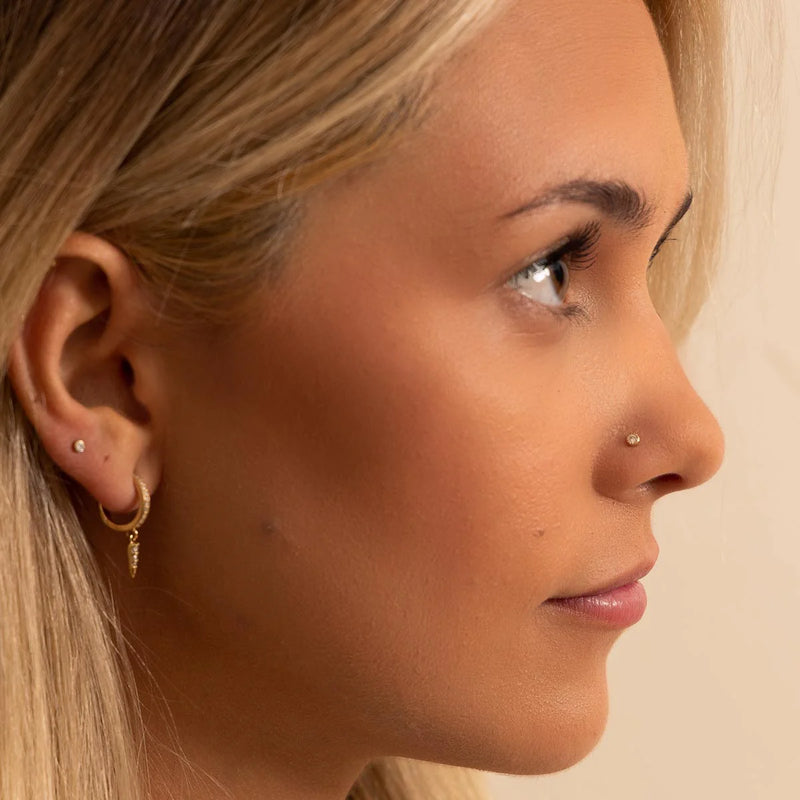 2mm diamond perlage flat back stud worn in nose piercing on model, showing minimalist gold look