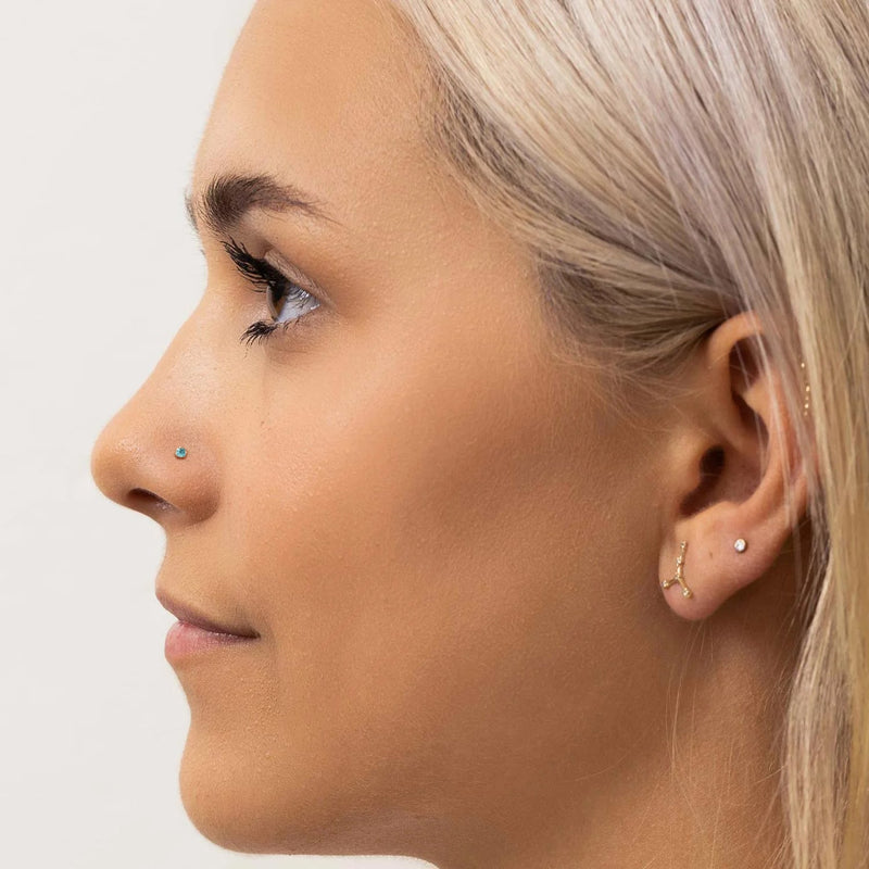 2mm aqua diamond nose ring shown in pierced nostril on model, side profile for fit reference