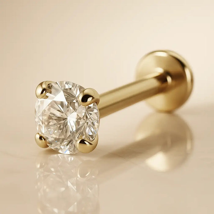Close-up of 2.5mm CZ in 4-prong martini setting on 14k yellow gold flat back labret, warm background