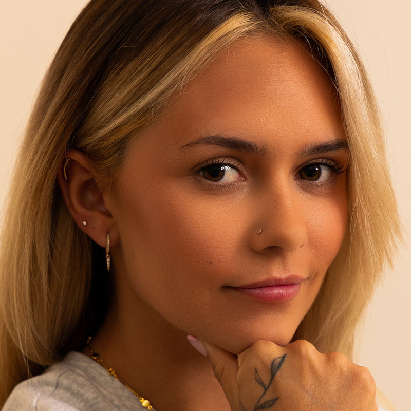 Diamond perlage nose ring in piercing on model looking directly forward, natural everyday wear look