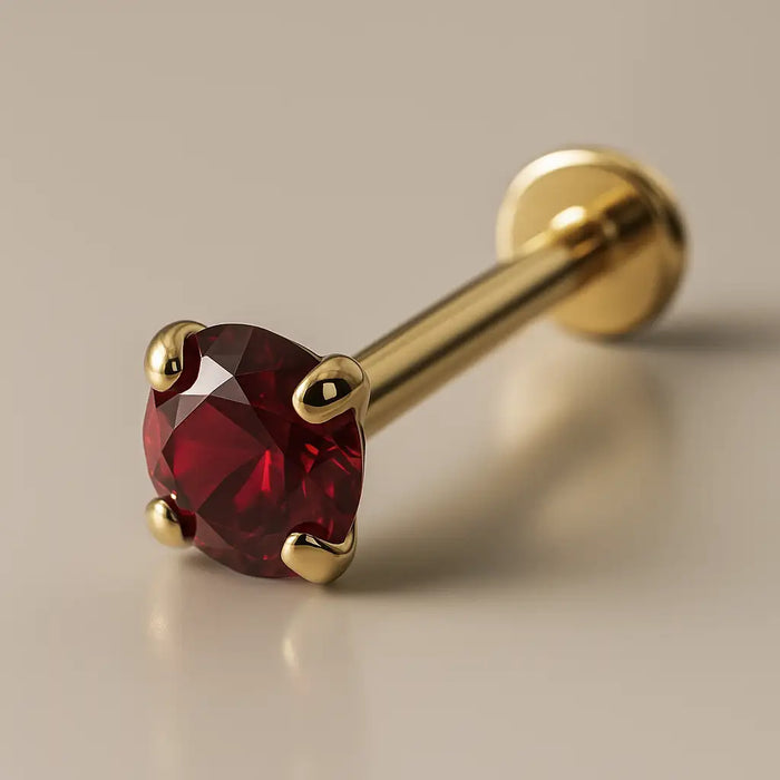 2mm ruby 14K yellow gold prong-set flat back labret, angled studio shot showing flat disc backing