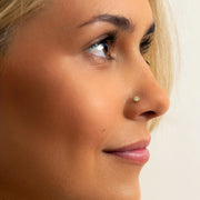 3mm diamond perlage nose ring in gold shown in pierced nose, side profile on model