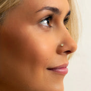 14k yellow gold 3mm diamond perlage flat back stud worn in model's nose piercing, side profile