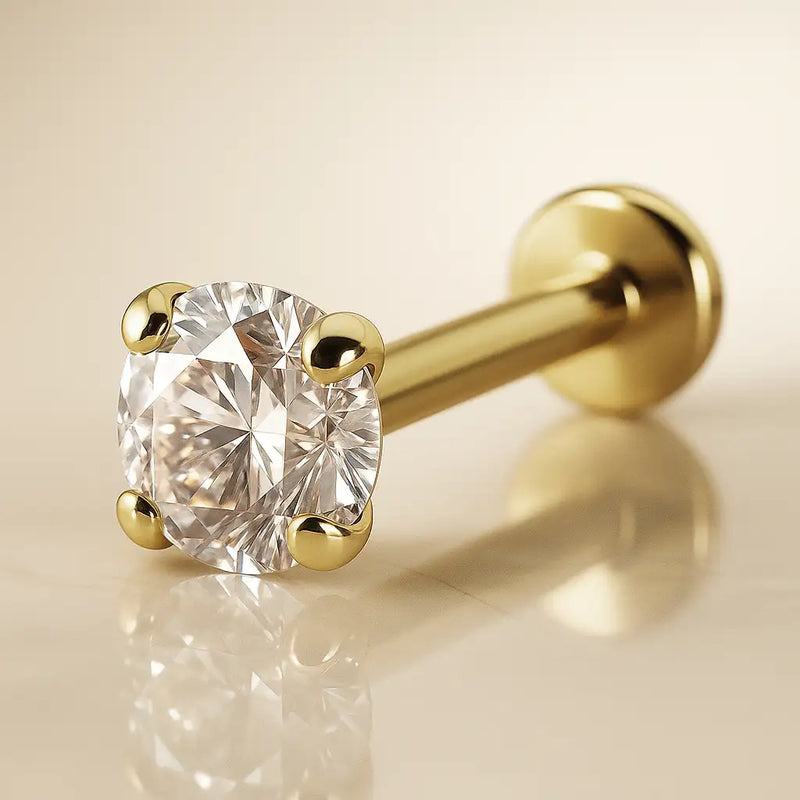 14k yellow gold 3.5mm CZ flat back labret on warm surface, side-angle lifestyle shot