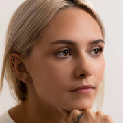 3mm diamond nose stud worn in piercing on blonde model looking upward, showing natural fit on nose