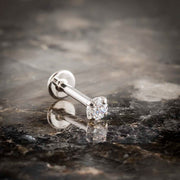 14k white gold 3mm diamond flat back labret stud on dark marble surface, angled lifestyle shot