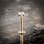 14k yellow gold 3mm diamond flat back labret stud standing upright on dark marble, front view
