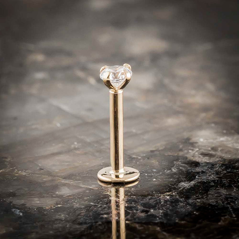 14k yellow gold 3mm diamond flat back labret stud standing upright on dark marble, front view