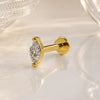 14k yellow gold 3mm marquise diamond flat back labret stud on marble surface, angled lifestyle shot