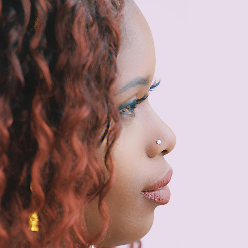 Side profile of model wearing 3mm diamond prong nose stud, showing placement on nose bridge