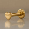 14k yellow gold tiny heart flat back labret showing polished heart charm and 3mm disc backing, angled view