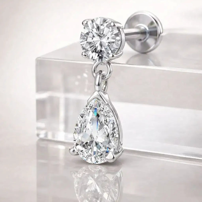 14k white gold diamond pear drop flat back stud on acrylic surface, angled view showing classic size sparkle
