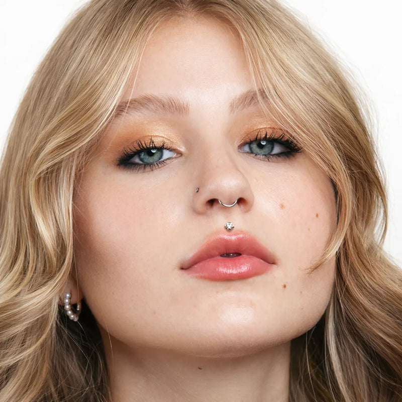 4mm CZ prong-set flat back labret shown in model's medusa piercing, front face view