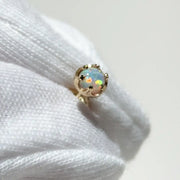 White gloves holding Reina crown setting with a 4mm Ethiopian opal