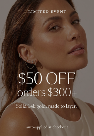 A promotional graphic featuring a close-up portrait of a woman wearing layered hoop earrings, with overlaid text reading 'LIMITED EVENT', '$50 OFF orders $300+', 'Solid 14k gold, made to layer.', and 'auto-applied at checkout'.