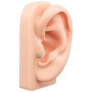 14K white gold diamond flower threadless stud in lobe piercing on silicone ear mannequin for size reference