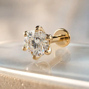 Gold Astra 4mm diamond stud flat back  earring with a clear gemstone on a reflective surface