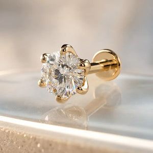 Gold Astra 4mm diamond stud flat back  earring with a clear gemstone on a reflective surface