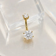 Gold moissanite belly button ring in 14k gold on a clear stand