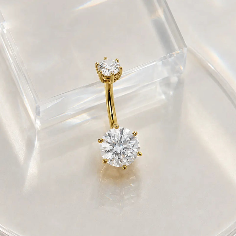Gold moissanite belly button ring in 14k gold on a clear stand