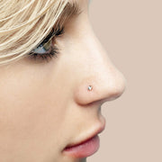Side profile of model wearing 2mm CZ bezel flat back stud in nose piercing, rose gold tone