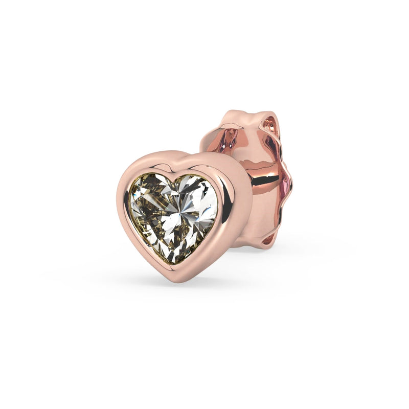 Single 14k rose gold white sapphire heart stud earring, angled view showing sparkling clear stone in pink bezel