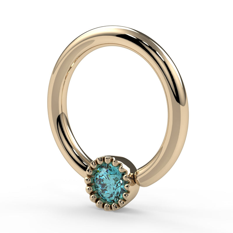Angled close-up of 14k yellow gold aqua diamond Perlagé ring highlighting the Perlage bezel and stone facets