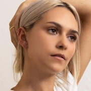 Virgo constellation 14k gold flat back earring worn in model's lobe piercing, styled ear stack