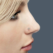 CZ flower flat back labret stud worn in nostril piercing, side profile view on blonde model