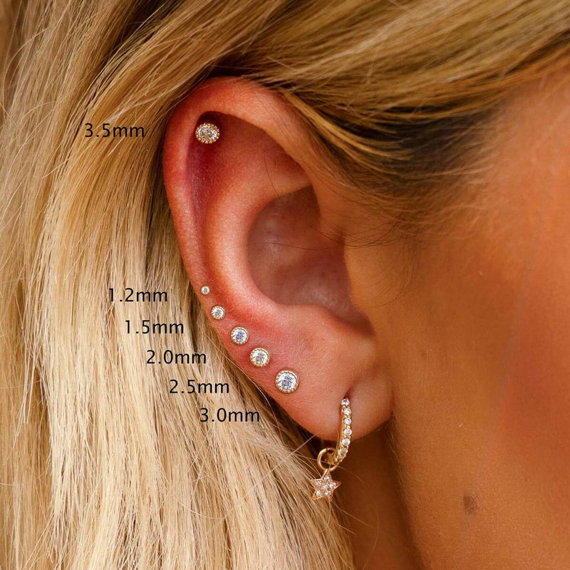Perlage diamond flat back studs sized 1.2mm to 3.5mm labeled on model's ear piercings for scale