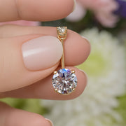 14k yellow gold 2.25 CTW diamond belly ring held between fingers for size reference