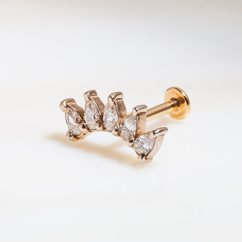 Angled view of 14k rose gold pear sapphire crescent labret showing flat back post and charm