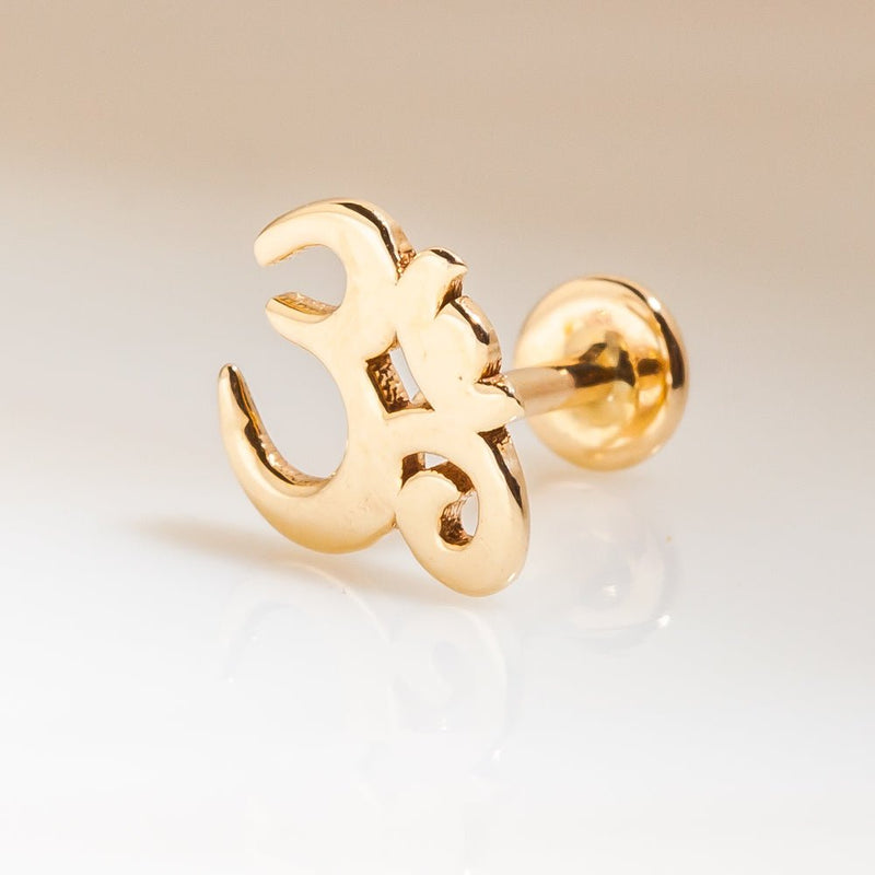 Side profile of 14k yellow gold Om symbol stud showing charm height and flat back post attachment