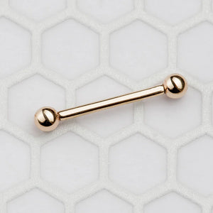 Single 14k rose gold straight barbell nipple ring close-up on white hexagonal tile surface