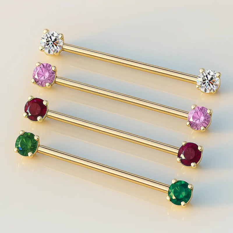 Four 14k yellow gold industrial barbells showing CZ color options: clear, pink, red, and green