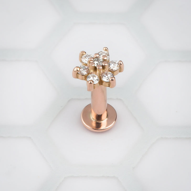 14k rose gold diamond flower flat back labret standing upright, showing flat disc base and post
