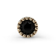 Close-up front view of 2mm black diamond milgrain bezel in 14k yellow gold nose ring end
