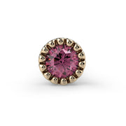 Close-up front view of 2mm pink diamond in 14k yellow gold perlage milgrain bezel setting