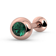 14K rose gold tongue barbell with emerald in solid bezel setting, angled view showing warm metal tone