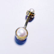 Close-up of bezel setting detail on 14k gold Akoya pearl navel ring, overhead view