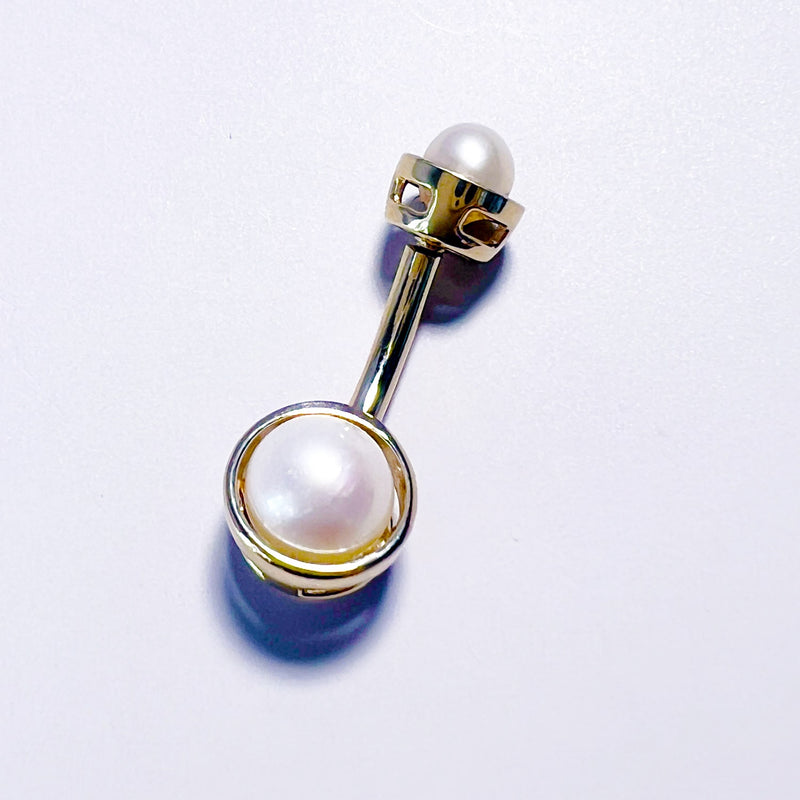 Close-up of bezel setting detail on 14k gold Akoya pearl navel ring, overhead view