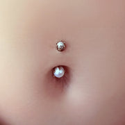 Close-up of Akoya pearl belly ring in navel piercing showing 3mm top and 5mm bottom pearl detail