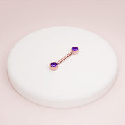 14K rose gold amethyst nipple barbell resting on white ceramic dish, styled product shot