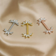 Angel wing nipple barbells in white gold, yellow gold, and rose gold shown side by side on satin